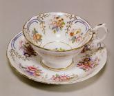 Чашка с блюдцем с изображением внутри букетов цветов и золоченых завитков