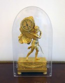 Часы каминные, бронзовые, золоченые с амуром, сбрасывающим покрывало с циферблата часов